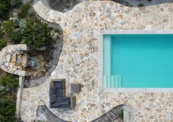 Aerial curved stone clad pool deck lounge Aerial curved stone clad pool deck lounge