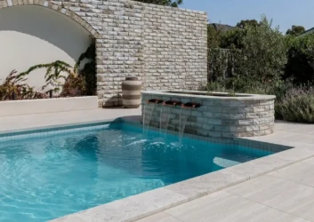 Stone clad pool water feature wall spouts Stone clad pool water feature wall spouts